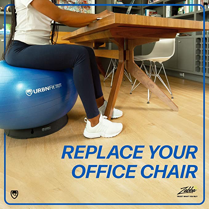 A person sitting on an exercise ball with stand holding it place as they work at their desk. 
